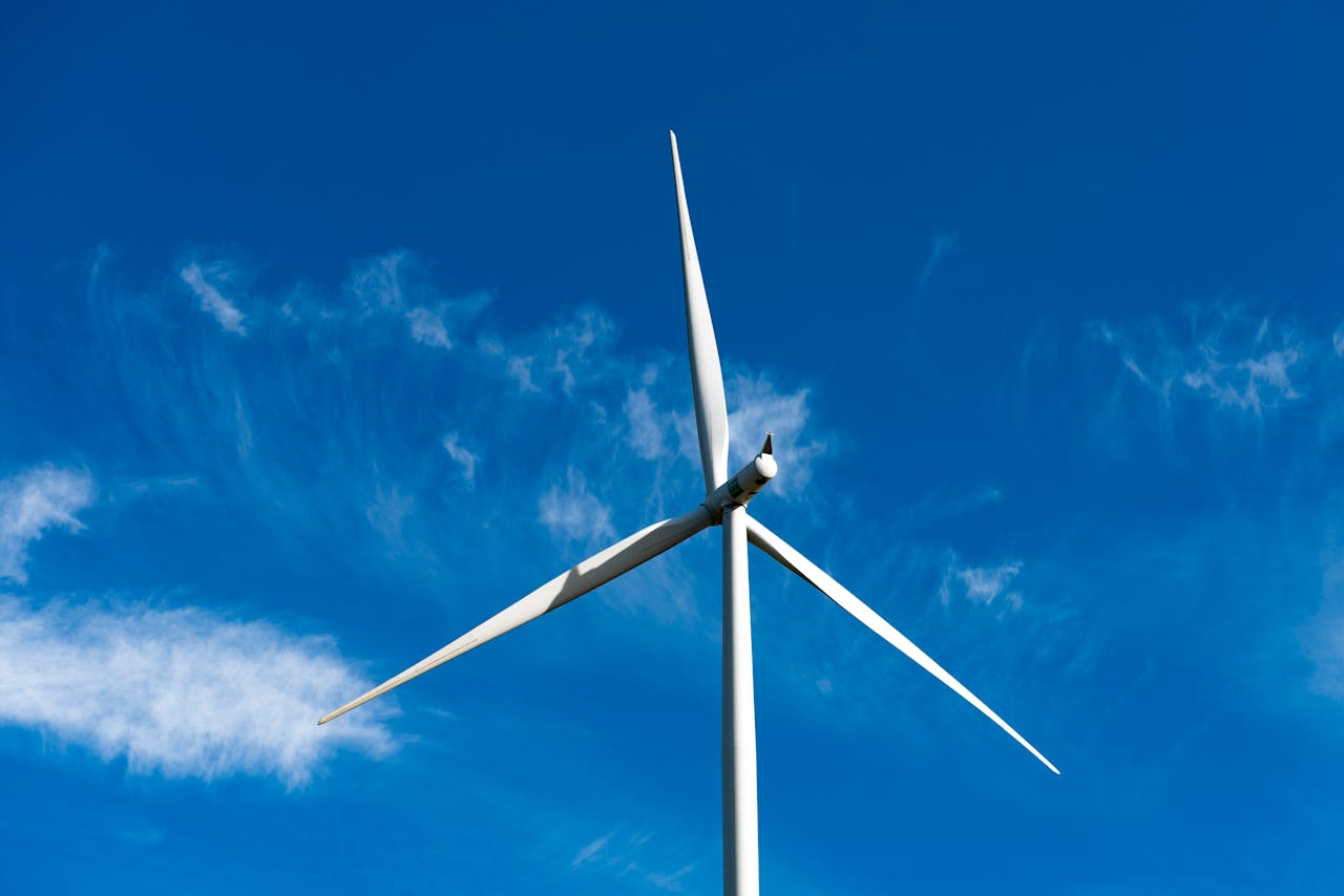 A powerful wind turbine stands tall under a clear blue sky, generating clean energy.